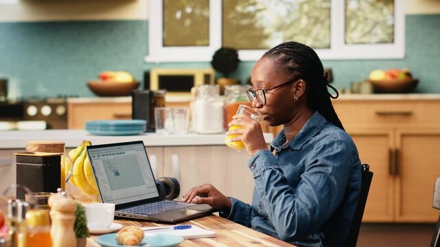 Black IT engineer working remotely coding on laptop and programming scripts on terminal windows at home, database management for high-tech digital engineering.