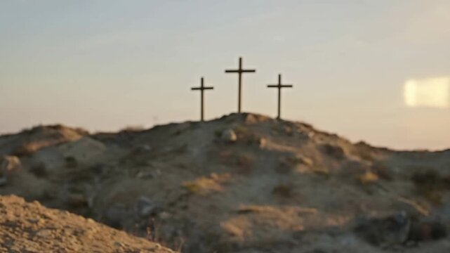 Roman soldier looking at the three crosses on Golgotha hill. Rack focus revealing the crucifixion site of Jesus Christ. Biblical Easter and Good Friday concept