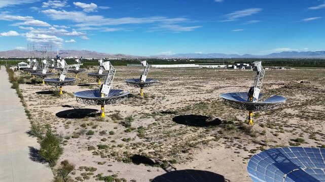 Rows of solar parabolic dish collectors in the desert landscape