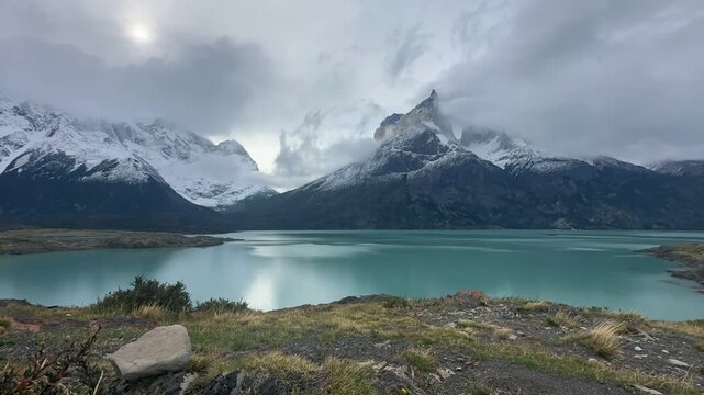 Clouds move over impressive mountain peaks, rocky peaks Cuernos del Paine and Lake Nordenskj&ouml;ld, time lapse, Torres del Paine National Park, Patagonia, Chile