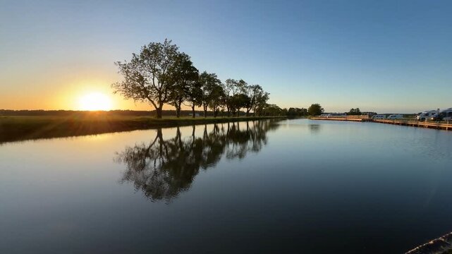 Peaceful canal at sunset, trees reflected in calm water, G&ouml;ta Canal, campground, Jonsboda Camping, T&ouml;reboda, V&auml;stra G&ouml;talands l&auml;n, Sweden