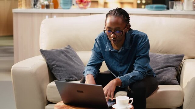 African american woman singing aloud at home and solving remote tasks, acting carefree and enjoying stress-free teleworking. Gen z freelancer being silly and multitasking, domestic life.