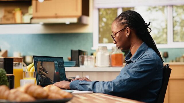 Designer engineer uses architectural software remodeling on laptop, sample of layout with measurements, detailed apartment blueprints.