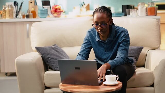 Young woman cracking knuckles due to nervous habit at home, making repetitive involuntary popping sound as she is focused on tasks.