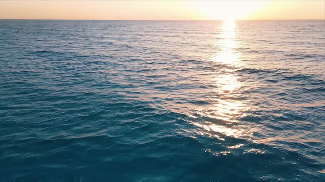 Golden Sunset over Tranquil Ocean Waves with Sun Reflection