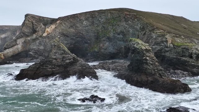 Waves at Storm on sea in slow motion over rocks and cliffs from a drone, St. Agnes, Cornwall, England, United Kingdom