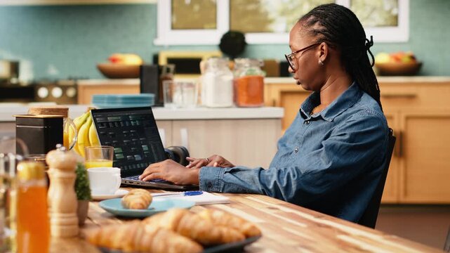Adult woman uses laptop to write programming code and develop software. Programmer focuses on debugging scripts, analyzing data and working with a terminal window in a digital work environment.