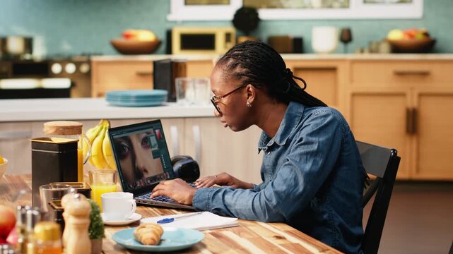 Photo editor retouching on laptop and selecting images in software during remote work, using color correction and visual effects to enhance photography.