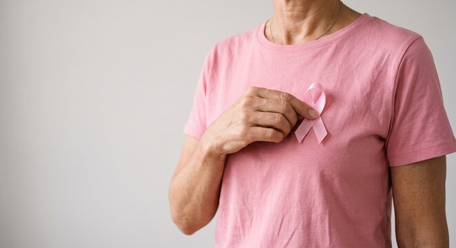 Woman holding pink ribbon for breast cancer awareness and prevention campaign