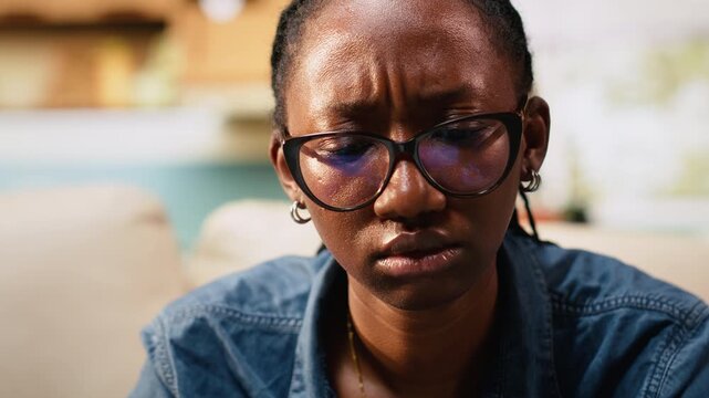 Close up of young woman frowning about ambiguous tasks at home, remote work on laptop indoors, disoriented disorganized freelancer unsure about telecommuting.