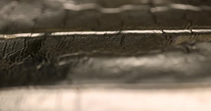  Metallic wrinkled foil background texture, shiny aluminum foil sheet with small brown dust particles on creased surface close up