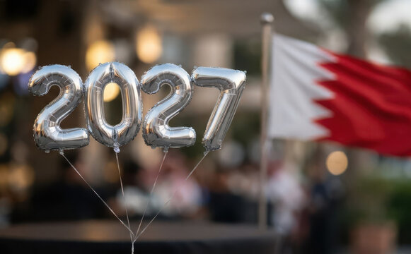 Silver foil balloons spelling the year 2027 with a national flag in the background, representing future celebration
