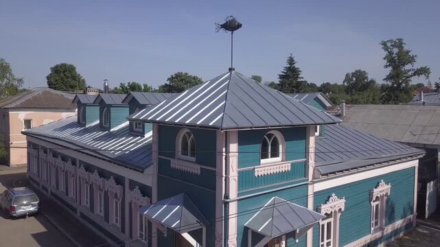 Drone rises and looks down on a blue roof