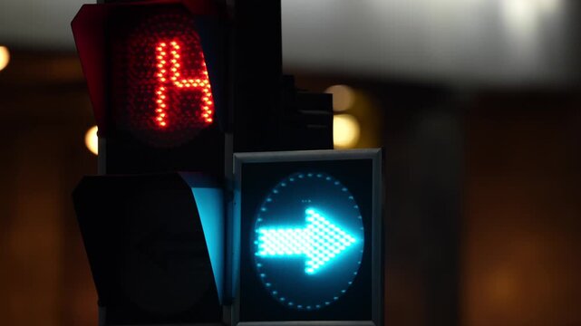 Modern traffic signal showing blue directional arrow and red stop light in an urban environment, representing traffic control, road safety, smart city infrastructure and transportation systems
