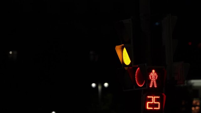 Illuminated pedestrian traffic signal at night showing red stop icon and countdown timer, representing road safety, urban infrastructure, smart city systems and pedestrian protection
