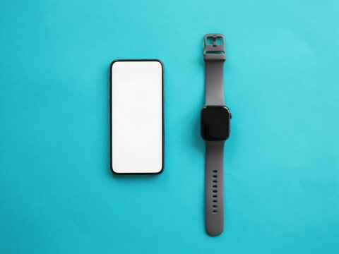 Smartphone and smartwatch with blank screens on a blue background