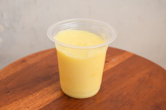 Fresh Yellow Mango Juice In Open Plastic Cup