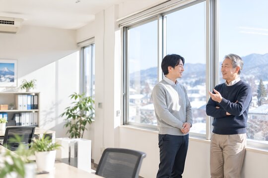 会社の将来を話し合う中小企業経営者と若い後継者