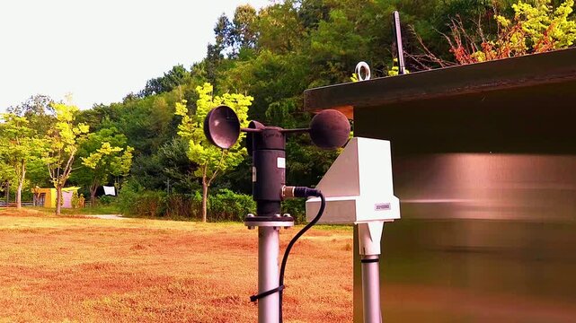 Close-Up of Cup Anemometer Measuring Wind Speed Against Forested Background