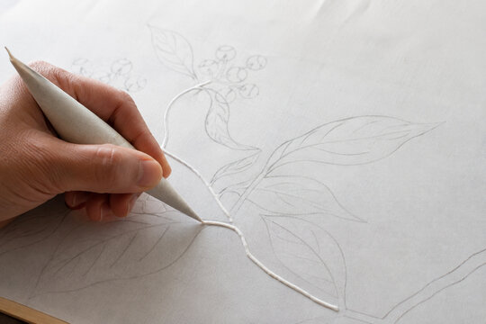 Artisan Applying White Resist Paste Along Silk Design