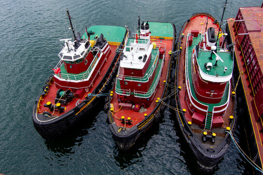 PORTLAND, MAINE &mdash; JUNE 21, 2018: Three tugboats are secured alongside one another in the waters of Portland Harbor.