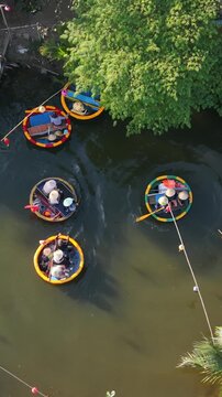 Vertical screen Small Boat Journey Through Canopies. Guided Coracle Ride Through Lush Canopy With Palm Clusters. Tourists Experience Scenic Waterway With Asian Guide And Shaded Canopy