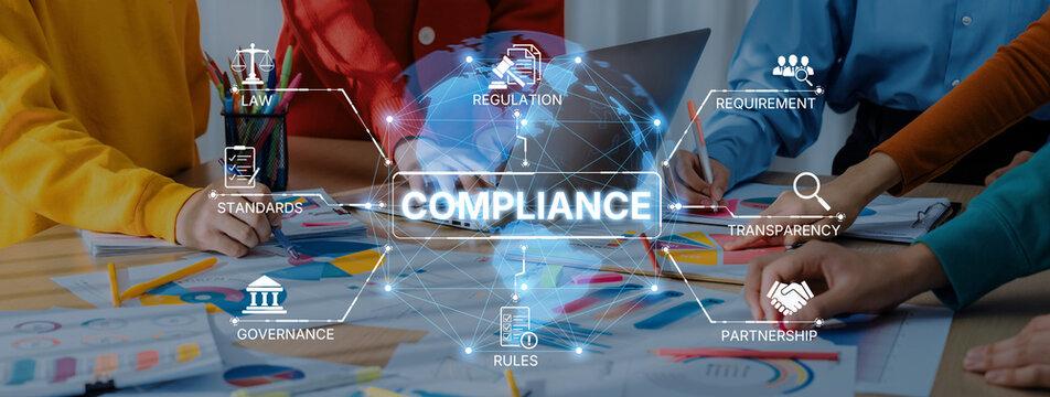 Diverse team members collaborate on a compliance strategy, analyzing graphic elements representing law, regulation, and governance in a modern office setting. Trope