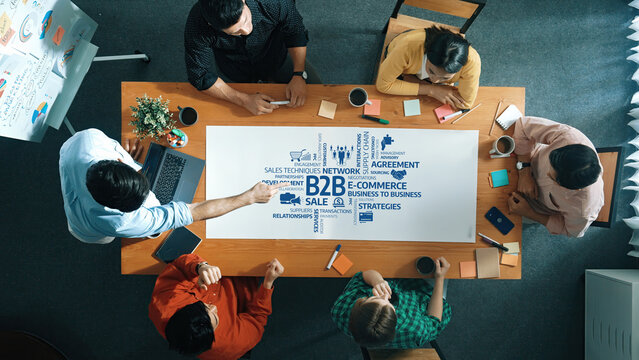 Engage in a dynamic business strategy meeting focused on B2B relationships and sales techniques. Professionals collaborate to develop innovative ideas and concepts in a modern workspace. Amity