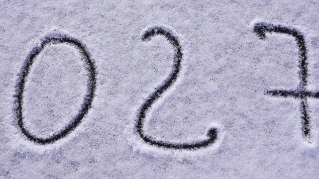 Written sketch for new year 2027. Snow background numbers ice outdoor on ground in winter. Writing text sign and drawing on field in nature frozen background. Copy space for text