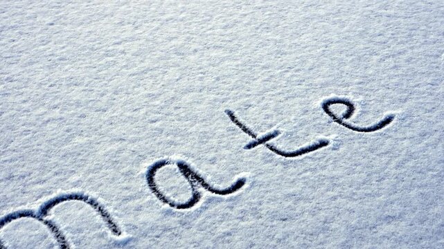 Written CLIMATE CHANGE on snow background message ice outdoor on ground in winter. Writing text sign drawing on field in frozen background. Weather changing cold season has arrived environment