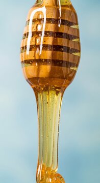 蜜すくい棒から滴る黄金の蜜、甘くておいしい自然の恵み