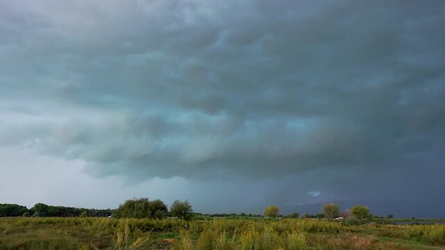 Panning view of a thunderstorm rolling in over Utah Valley as lightning flashes in the clouds.