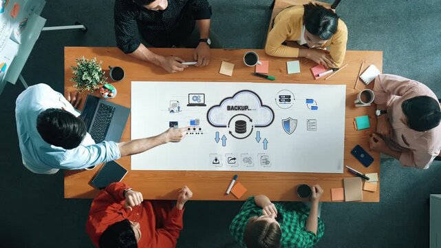 Collaborative Discussion on Cloud Backup Solutions with Diverse Team at Modern Workspace Featuring Technology Concepts and Graphics Sigmoid