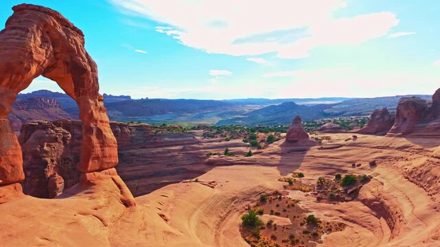 Golden sunset light glows over the iconic Delicate Arch and surrounding rim in Arches National Park