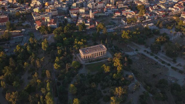 Stunning aerial perspective showing the ancient Temple of Hephaestus, nestled among lush trees within the historic Agora of Athens, Greece, illuminated by the warm glow of the rising sun