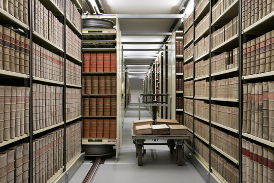 Closed stack library aisle between tall shelves of bound volumes