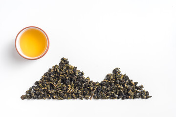 Obraz premium Top view creative flat lay of oolong tea leaves arranged in mountain shape with teacup as sun on white background with copy space