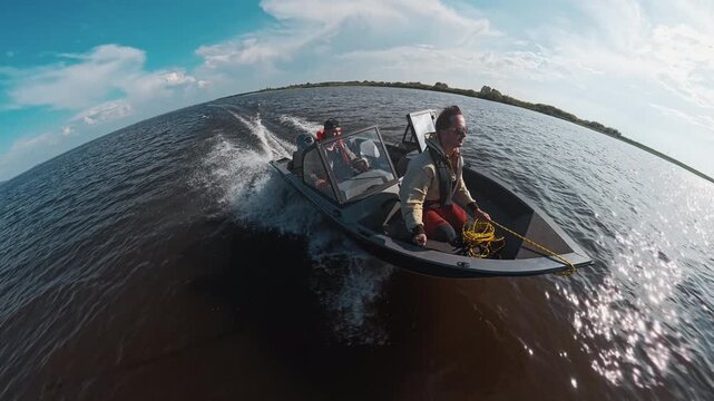Two fishermen explore the river on the speed motor boat