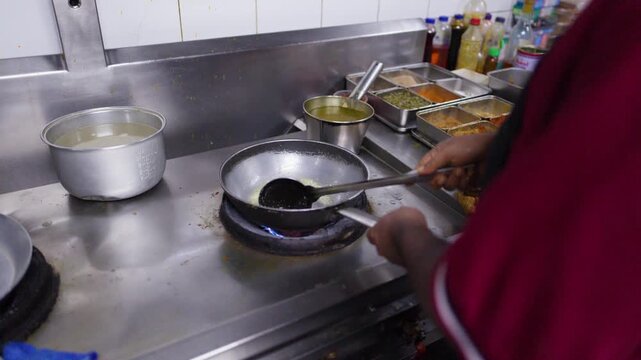Chef Cooking Curry in Commercial Kitchen with Pan and Ladle