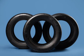 Black car tires on blue background © Pixel-Shot