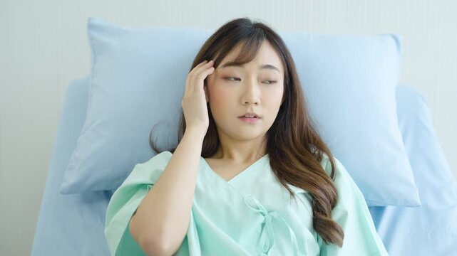 Sick pregnant woman touching forehead while resting in hospital bed, headache, pregnancy discomfort, fatigue, prenatal healthcare, maternity illness and patient recovery.
