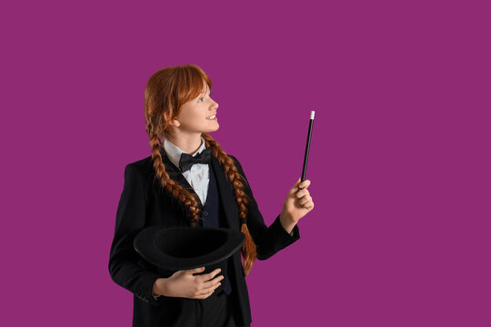 Young magician showing magic trick on purple background
