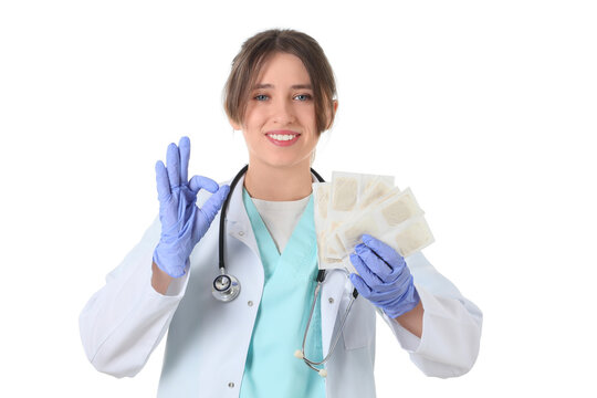 Female doctor with mustard plasters showing OK on white background