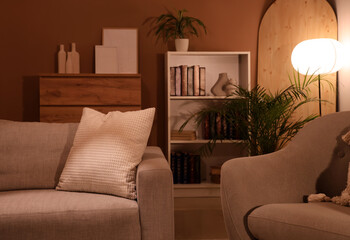 Interior of living room with comfortable sofa, bookcase and armchair © Pixel-Shot