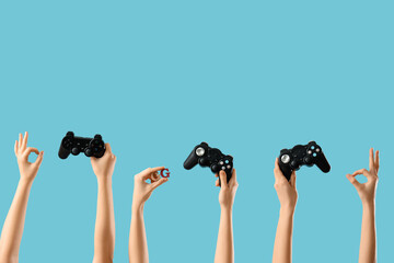 Female hands with game pads showing OK on blue background © Pixel-Shot