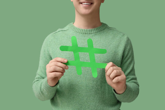 Man with hashtag sign on green background, closeup
