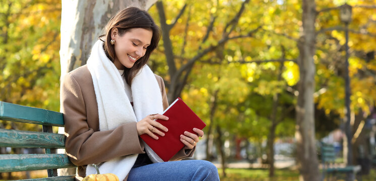 Mindfulness and mental health, young woman reading a book on a park bench during autumn for relaxation and personal growth in a peaceful outdoor setting