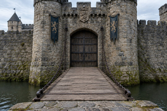 Medieval castle entrance with lowered drawbridge and stone moat, historical architecture concept