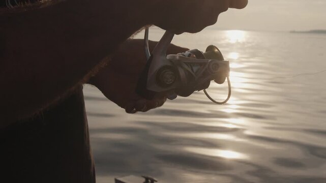 Amateur angler fishing on the river from a boat at sunset