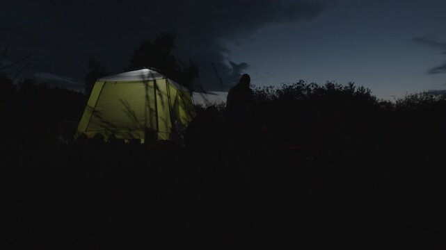 Group of men camping in the wild and gather near the bonfire and talk with each other. Fishermen camping and talk stories at night